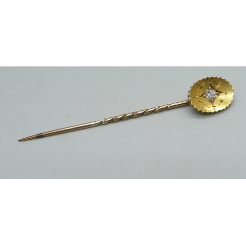 910 - A yellow metal stick pin set with a diamond, 2.6g, cased