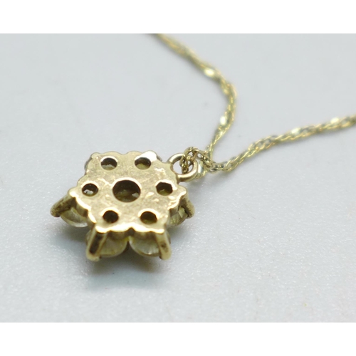 953 - A seven stone yellow metal pendant, (tests as 9ct gold), on a 9ct gold chain, 1.7g