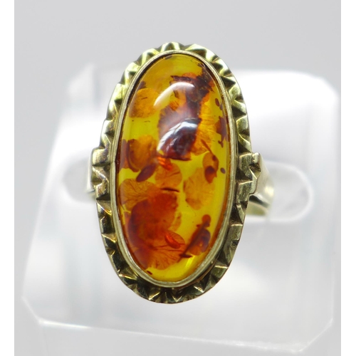 983 - A 9ct gold and amber ring, with insect inclusion, with London import mark for 1979, 3.9g, N