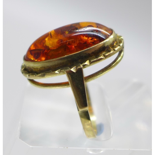 983 - A 9ct gold and amber ring, with insect inclusion, with London import mark for 1979, 3.9g, N