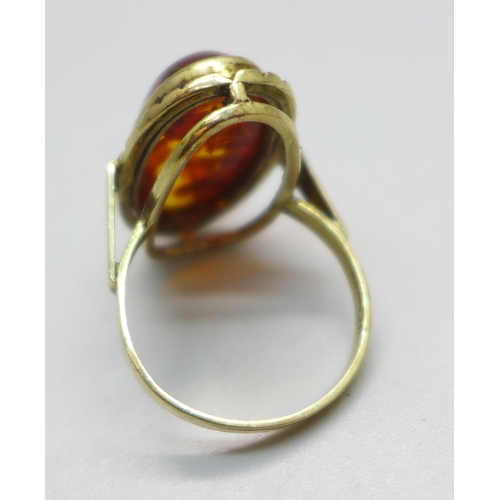 983 - A 9ct gold and amber ring, with insect inclusion, with London import mark for 1979, 3.9g, N