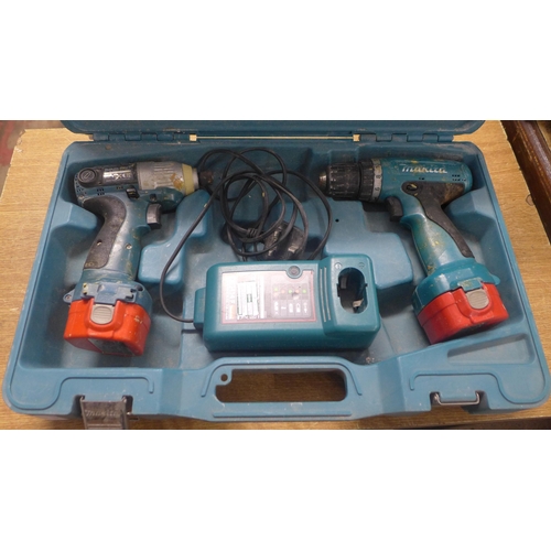 2028 - 2 Makita drills with two batteries and a charger (Models 6980FD and 6270D)