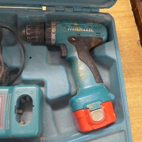 2028 - 2 Makita drills with two batteries and a charger (Models 6980FD and 6270D)