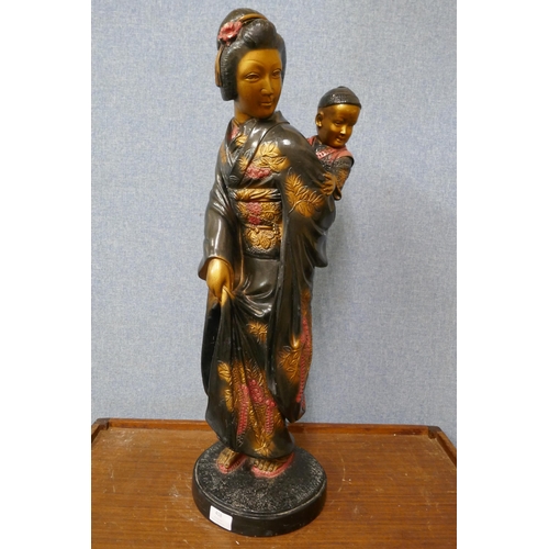 418 - An oriental painted plaster figure of a mother and child