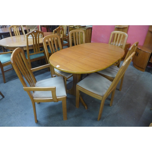 142 - A teak oval extending dining table and six chairs