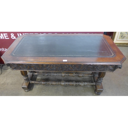 241 - A Victorian Jacobean Revival carved oak and leather topped two drawer writing table