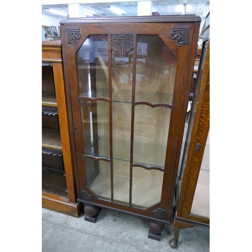 261 - A carved oak single door display cabinet