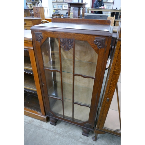 261 - A carved oak single door display cabinet