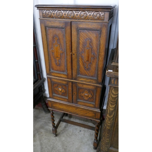 277 - A carved oak barleytwist four door cupboard