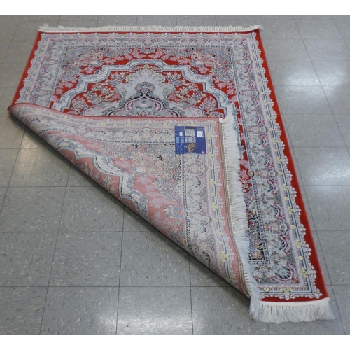 282 - An Iranian red ground rug, 242cm x 162cm