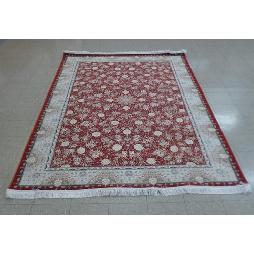 285 - An Iranian red ground rug, 308cm x 201cm