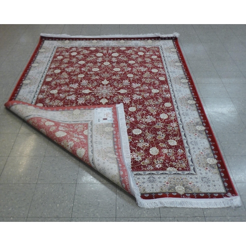 285 - An Iranian red ground rug, 308cm x 201cm