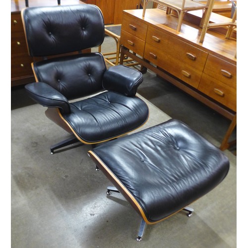 154 - A Charles & Ray Eames style simulated rosewood and black leather revolving lounge chair and ottoman