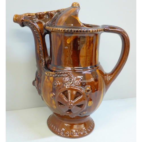 607 - A treacle glaze pottery puzzle jug, 26cm