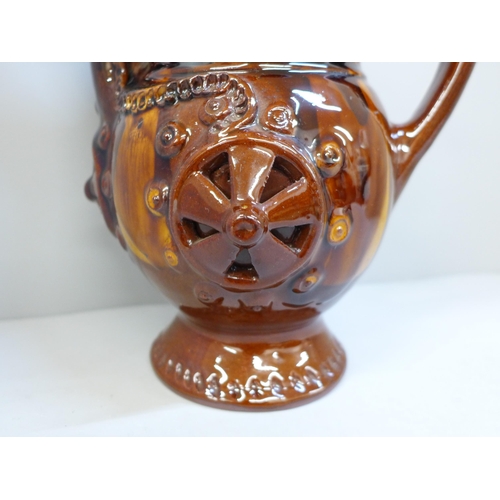 607 - A treacle glaze pottery puzzle jug, 26cm