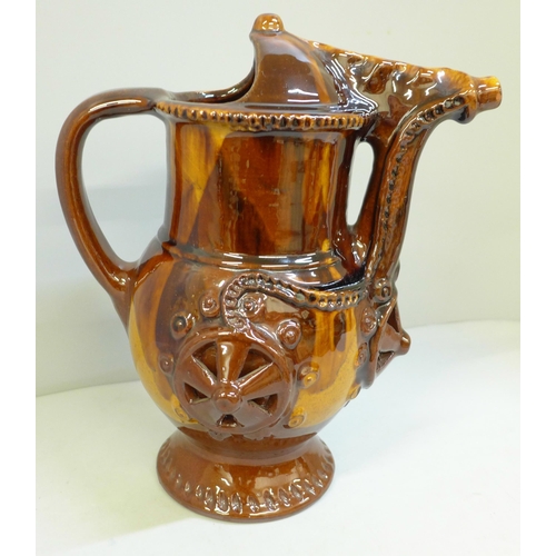 607 - A treacle glaze pottery puzzle jug, 26cm