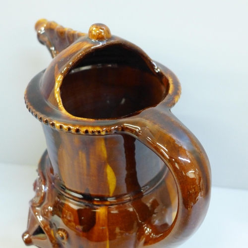 607 - A treacle glaze pottery puzzle jug, 26cm