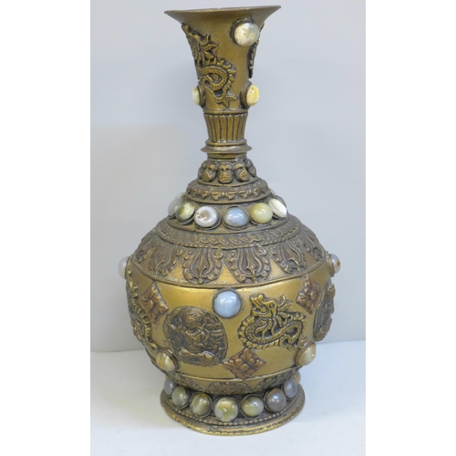 610 - An embossed Tibetan brass vase set with thirty-nine cabochon stones, 24cm