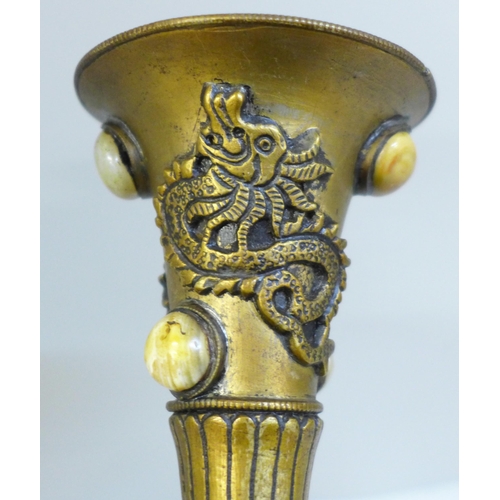 610 - An embossed Tibetan brass vase set with thirty-nine cabochon stones, 24cm