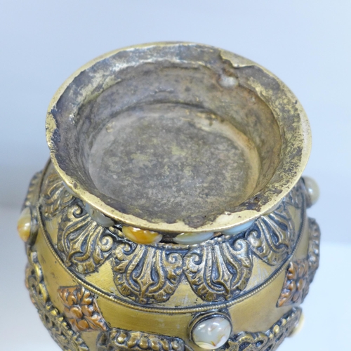 610 - An embossed Tibetan brass vase set with thirty-nine cabochon stones, 24cm