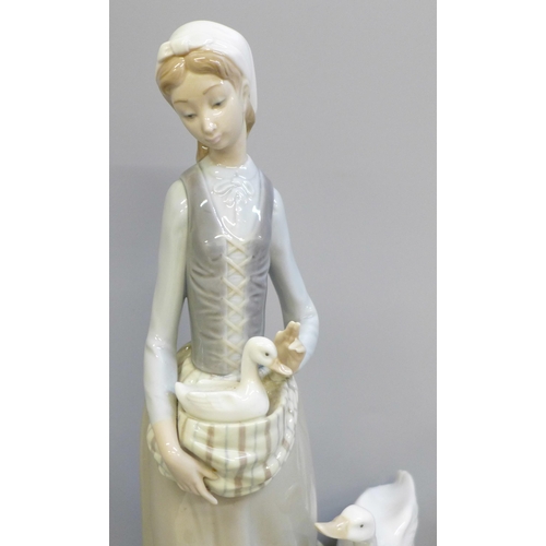 612 - A Lladro figure, girl with geese, 31cm and a German figure of a girl feeding a fawn