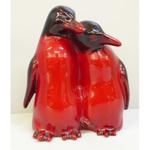 628 - A rare Royal Doulton flambe penguin pair figure group, HN133, 15cm, (fine crack on the bill of the l... 