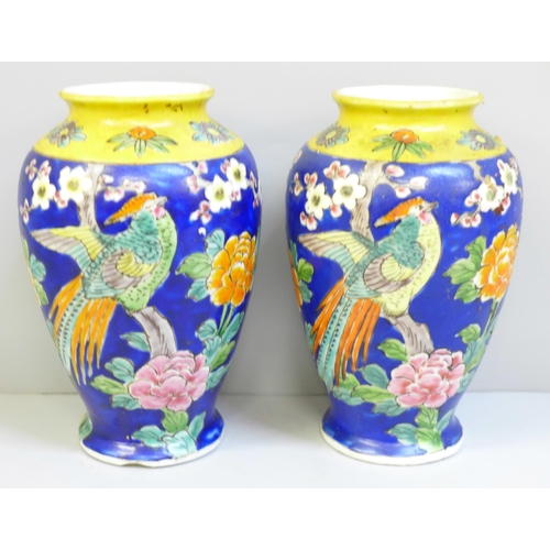 652 - A pair of Japanese blue and yellow vases decorated with birds and flowers, chip to one base, 15cm