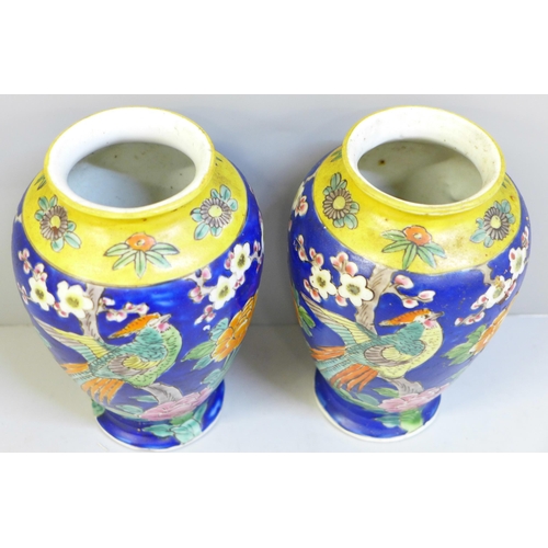 652 - A pair of Japanese blue and yellow vases decorated with birds and flowers, chip to one base, 15cm