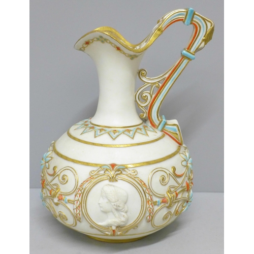 775 - A late 19th Century ewer, decorated in blue, orange and gold against a cream ground with two circula... 