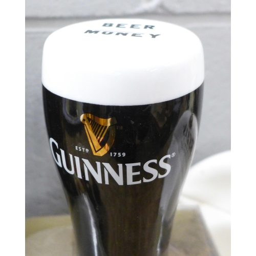 789 - A large pottery Guinness pint glass money bank, one smaller, a Guinness mug and coaster set, boxed, ... 