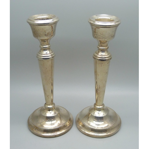 815 - A pair of silver candlesticks with weighted bases, 15.5cm