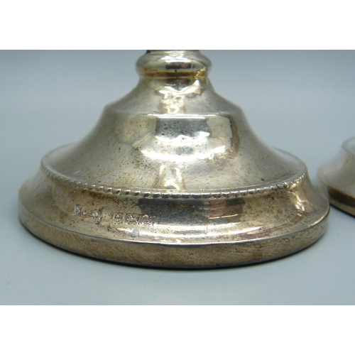 815 - A pair of silver candlesticks with weighted bases, 15.5cm