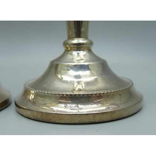 815 - A pair of silver candlesticks with weighted bases, 15.5cm