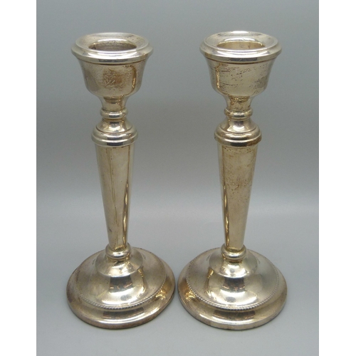 815 - A pair of silver candlesticks with weighted bases, 15.5cm