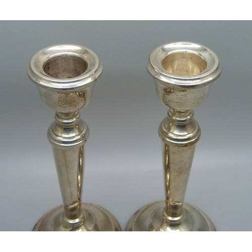 815 - A pair of silver candlesticks with weighted bases, 15.5cm