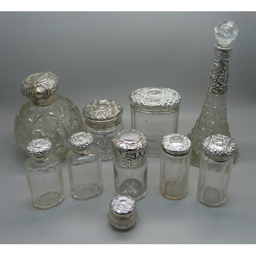 837 - Ten silver topped glass bottles including a globular glass scent bottle, lid a/f