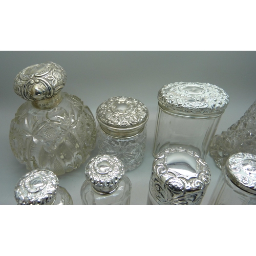 837 - Ten silver topped glass bottles including a globular glass scent bottle, lid a/f