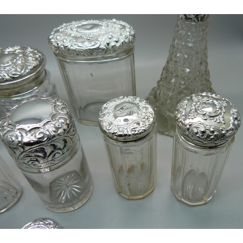 837 - Ten silver topped glass bottles including a globular glass scent bottle, lid a/f