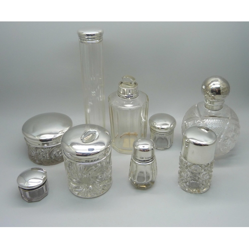 879 - Nine silver topped glass bottles and jars