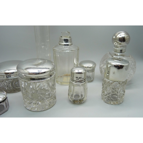 879 - Nine silver topped glass bottles and jars