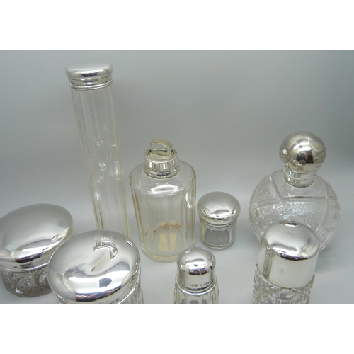 879 - Nine silver topped glass bottles and jars