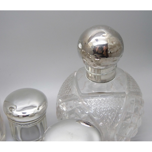 879 - Nine silver topped glass bottles and jars