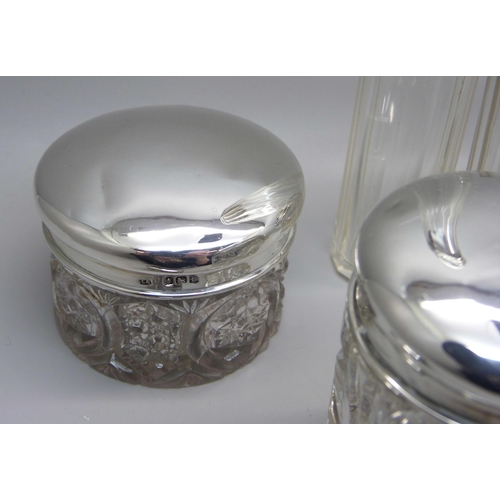 879 - Nine silver topped glass bottles and jars