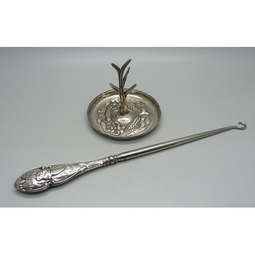 915 - A silver ring stand, 20g and a silver handled button hook