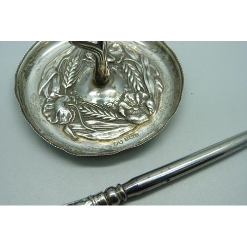 915 - A silver ring stand, 20g and a silver handled button hook