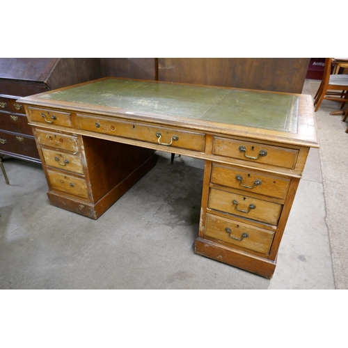 127 - An Edward VII oak and green leather topped pedestal desk