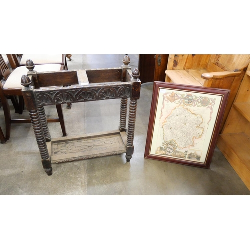 171 - An early 20th Century carved oak stick stand and a map of Herefordshire print