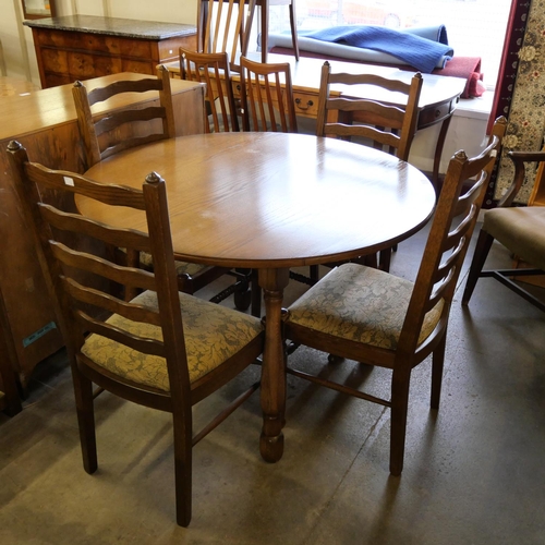 184 - A circular oak dining table and four chairs