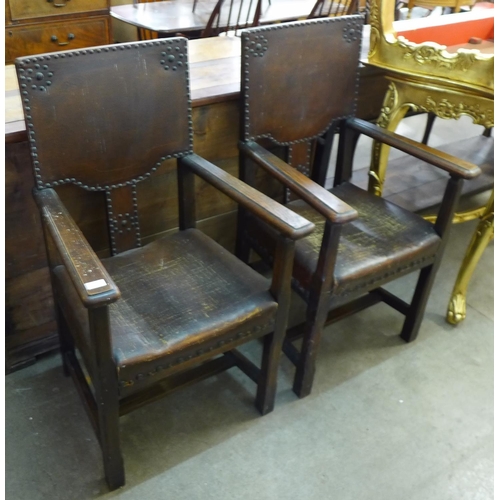 201 - A pair of early 20th Century oak and brown eather armchairs