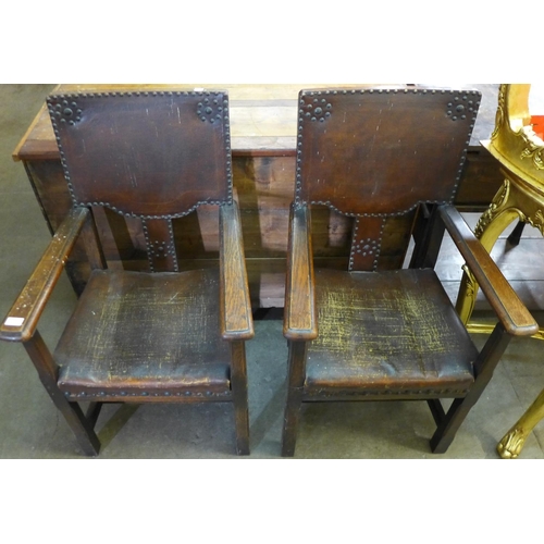 201 - A pair of early 20th Century oak and brown eather armchairs